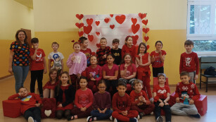 Walentynki4 – Uczniowie klasy 2b wraz z wychowawcą na tle walentynkowej dekoracji