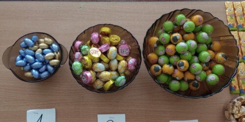 Zdjęcie 3 przedstawia jajka czekoladowe o różnych kolorach opakowań w 3 oddzielnych miskach