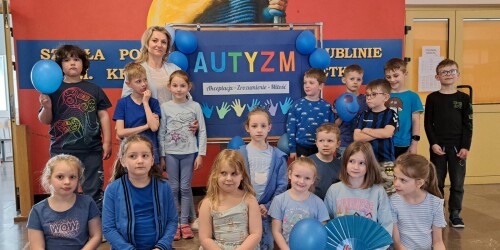 5.	Dzień Świadomości Autyzmu, Uczniowie klasy 1e ubrani na niebiesko, przed tablicą na temat autyzmu.